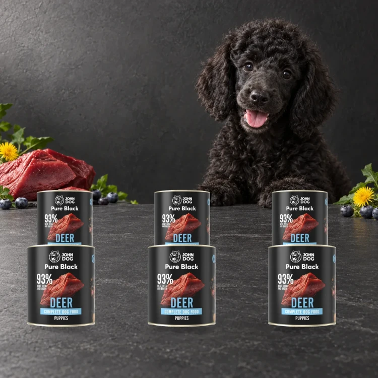 Zestaw 6 puszek karmy mokrej John Dog Jeleń Pure Black Junior po 800 g obok szczeniaka
