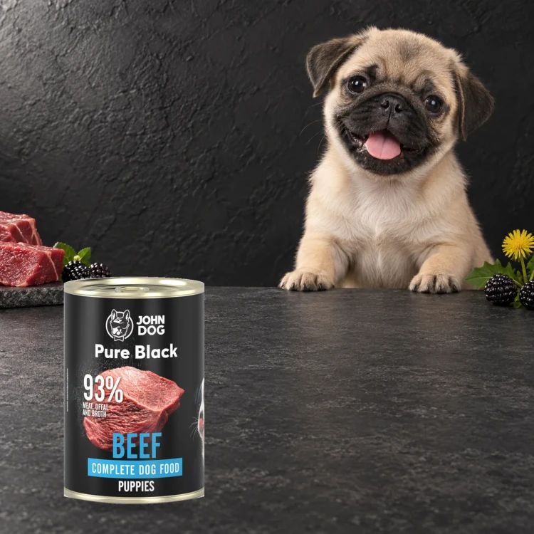 Puszka karmy mokrej John Dog Wołowina Pure Black Junior 400 g obok szczeniaka
