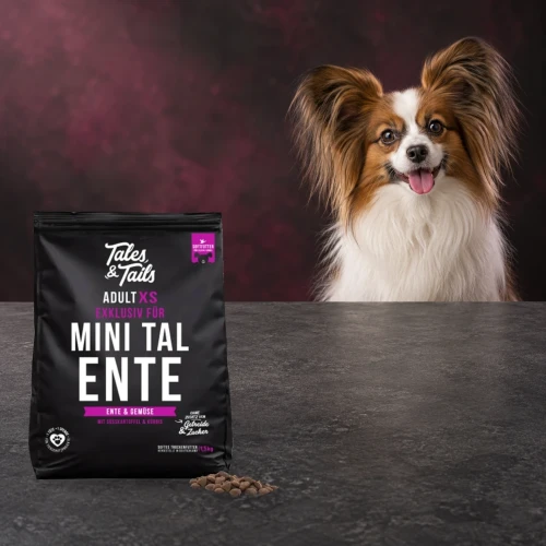 Karma półwilgotna Tales & Tails 1,5 kg z kaczką dla dorosłych psów małych ras obok małego psa.