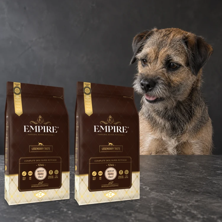 Dwa worki karmy EMPIRE Legendary Taste Adult Daily Diet dla małych i średnich psów po 12 kg obok border terriera na ciemnym tle