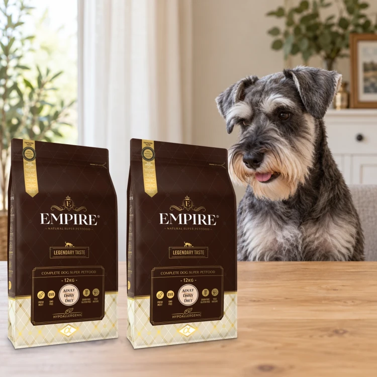 Dwa worki karmy EMPIRE Legendary Taste Adult Daily Diet dla małych i średnich psów po 12 kg obok sznaucera miniaturowego w mieszkaniu