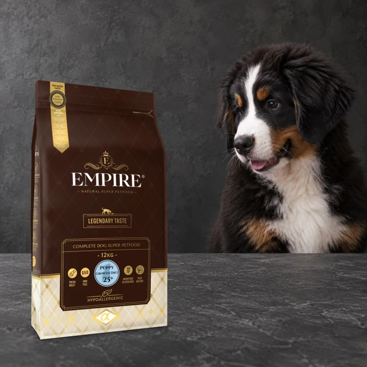 Worek karmy EMPIRE Legendary Taste Puppy Growth Diet 25+ dla szczeniąt dużych ras 12 kg obok szczeniaka berneńskiego psa pasterskiego na ciemnym tle