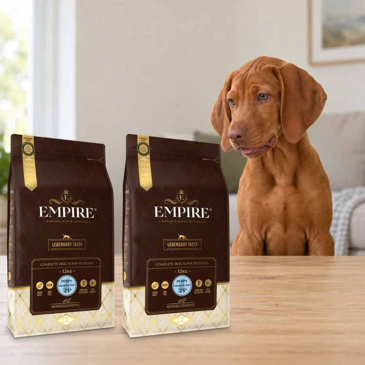 Dwa worki karmy EMPIRE Legendary Taste Puppy Growth Diet 25+ dla szczeniąt dużych ras po 12 kg obok szczeniaka wyżła węgierskiego w mieszkaniu