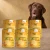 Sześć puszek karmy Syta Micha Indyk z warzywami 6 × 400 g obok psa rasy Labrador retriever na tle w kolorach opakowania