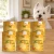 Sześć puszek karmy Syta Micha Indyk z warzywami 6 × 400 g obok psa rasy West Highland white terrier w mieszkaniu