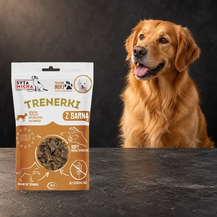 Trenerki Syta Micha z sarną 80 g obok psa na ciemnym tle.
