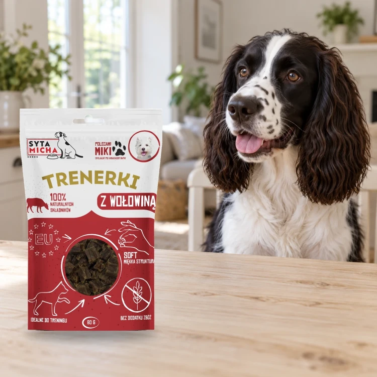 Trenerki Syta Micha z wołowiną 80 g obok psa w domu.