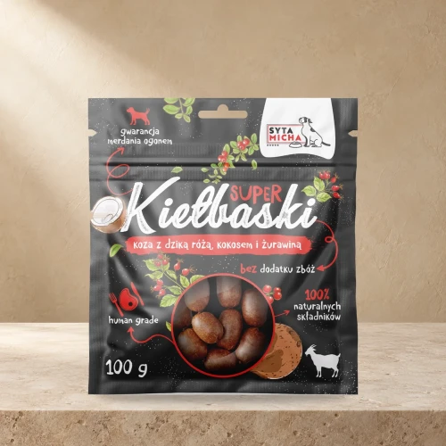 Kiełbaski Syta Micha koza z dziką różą, kokosem i żurawiną 100 g na jasnym blacie