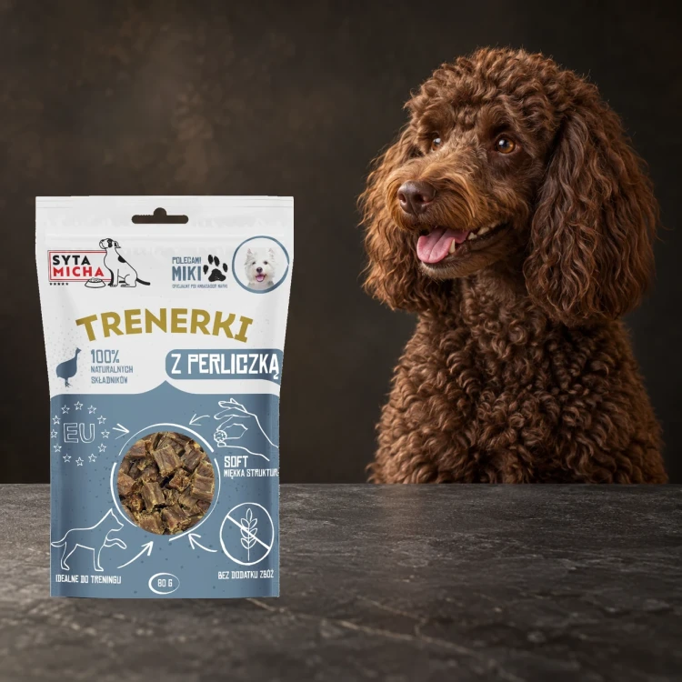Trenerki Syta Micha z perliczką 80 g obok psa na ciemnym tle.