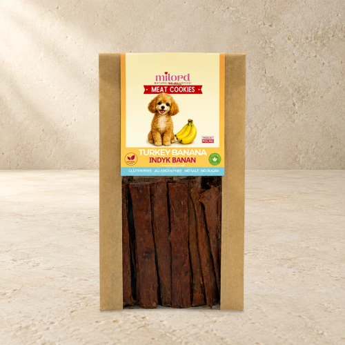 Opakowanie przysmaków Indyk z Bananem 80g na jasnym tle.