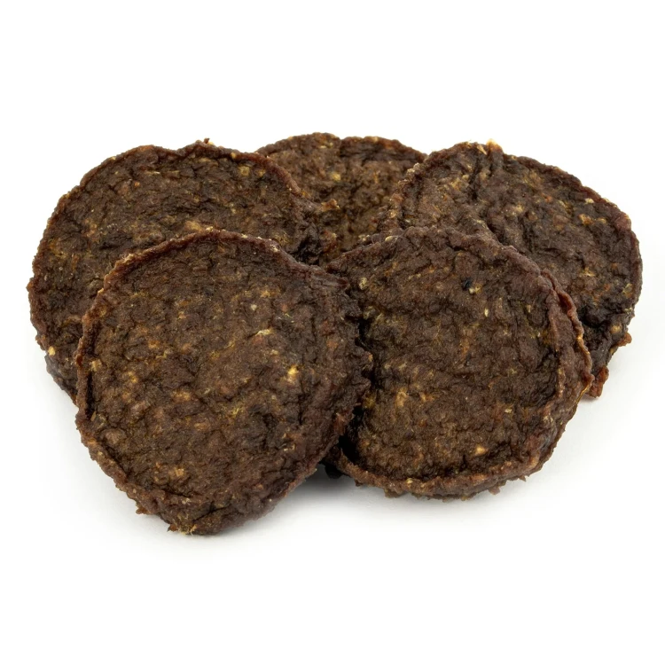Kilka ciemnobrązowych burgerów SANA Dog ułożonych jeden na drugim, z widoczną ziarnistą fakturą