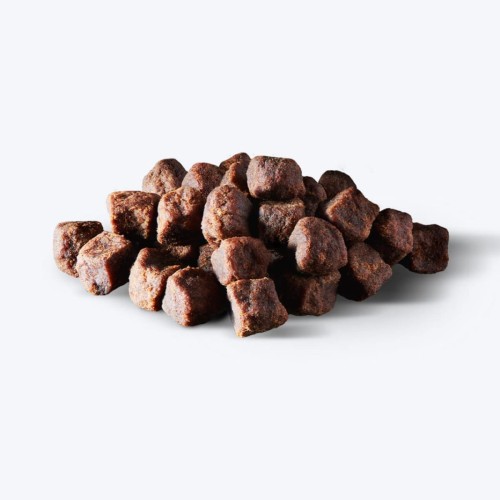 Drobne brązowe kawałki John Dog Chapsy Soft Bits Plant Based, usypane na jasnym tle
